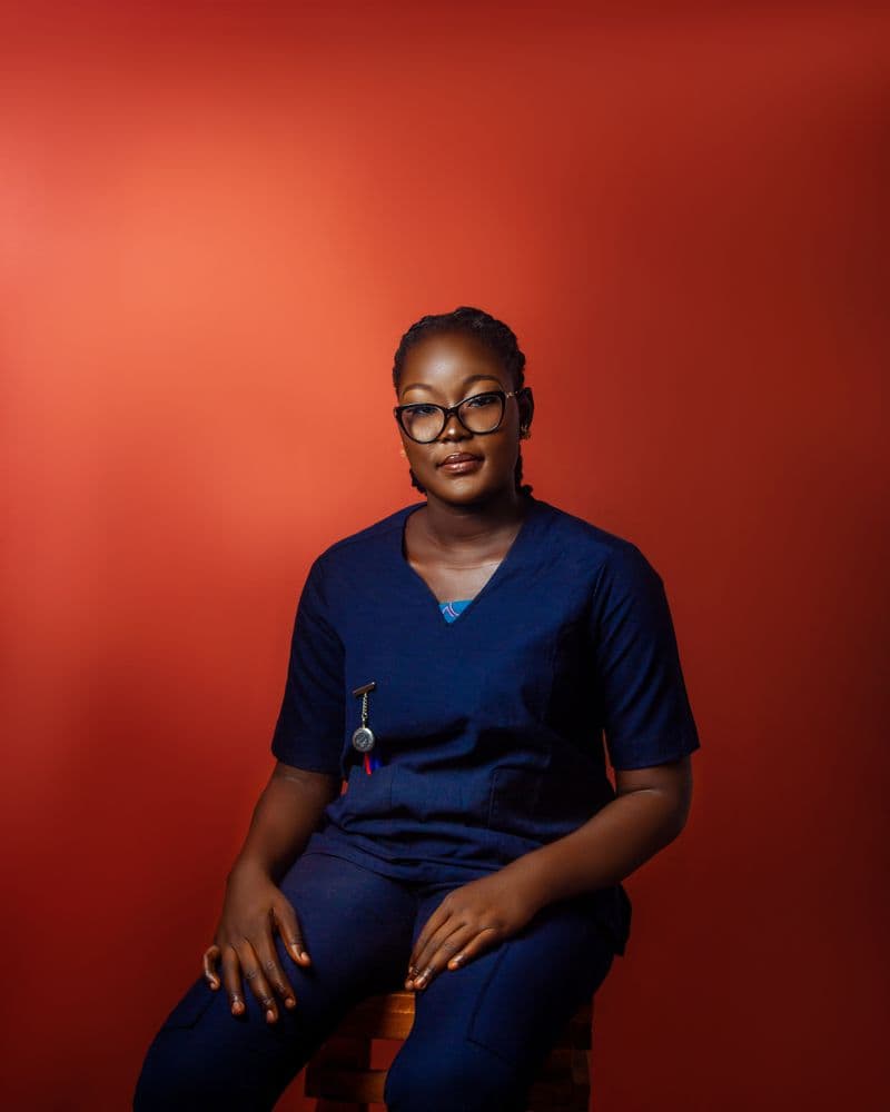 Portrait of Dr. Adaeze Nwosu, DVM, a veterinarian at Riverbend Animal Hospital, wearing navy scrubs and glasses