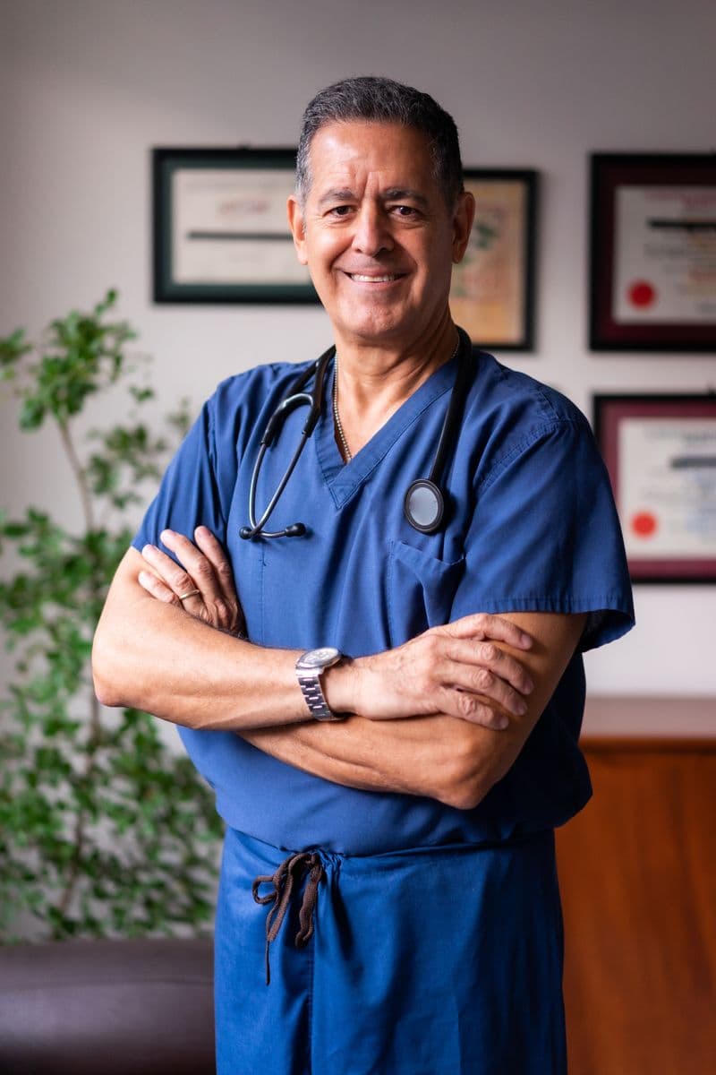 Portrait of Dr. Marcus Rowe, DVM, a veterinarian at Riverbend Animal Hospital, smiling in blue scrubs