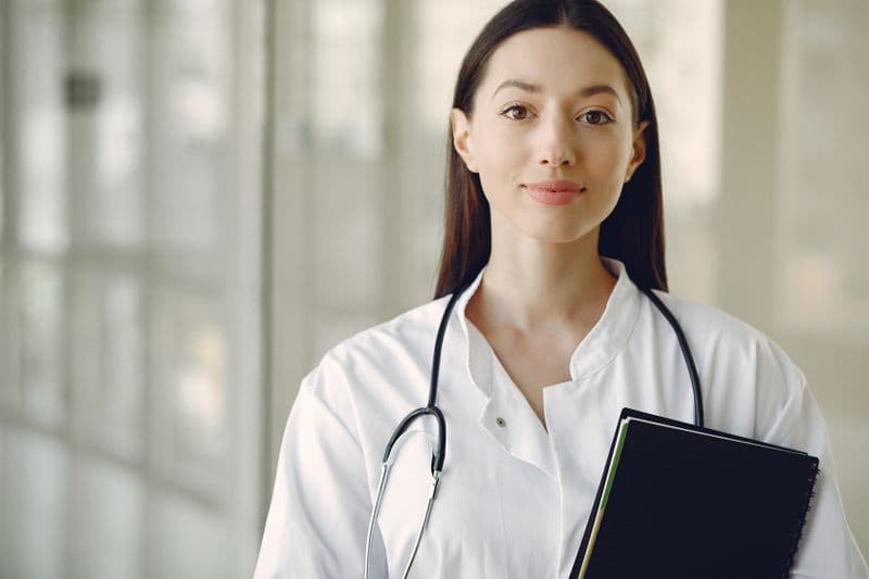 Portrait of Priya Anand, Certified Veterinary Technician at Riverbend Animal Hospital, wearing a white coat